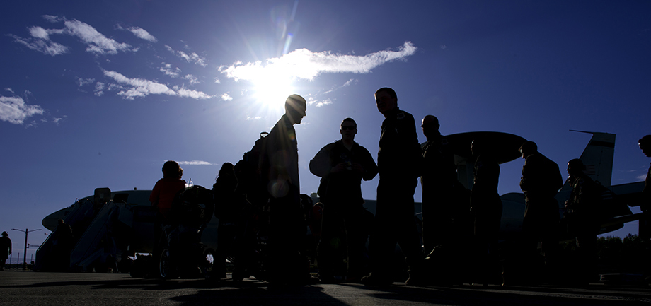 Connect to Care - image: Airmen silhouetted by bright sun next to an E3 Sentry Airborne Warning And Control Systems aircraft.